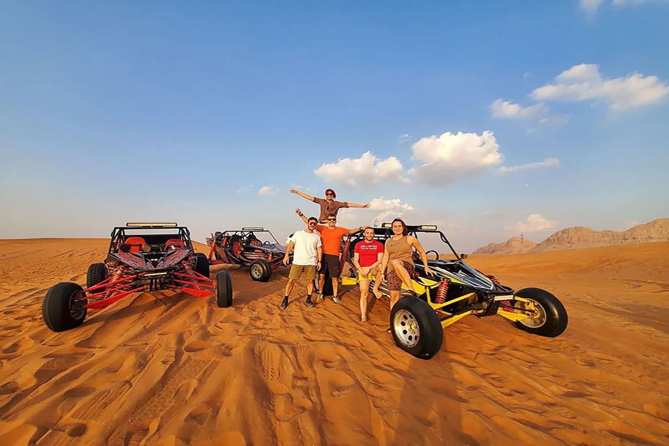 A group gathered beside custom buggies in the desert
