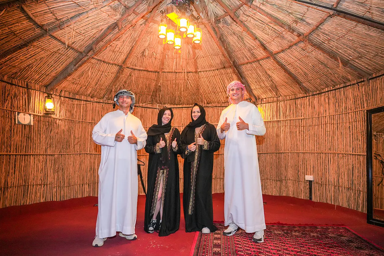 Visitors in traditional dress inside a desert camp tent in Dubai